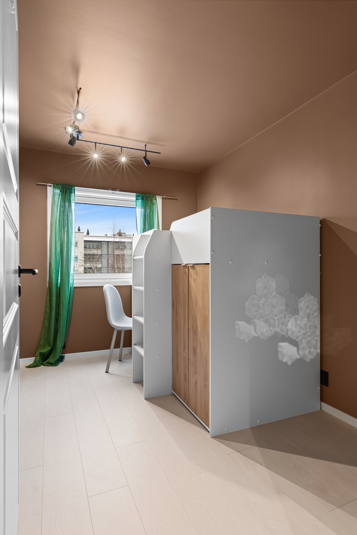 Praktisk barne-/ungdomsrom med plassbygget køyeseng og skriveplass ved vinduet - et rom som utnytter arealet godt. Galleribilde