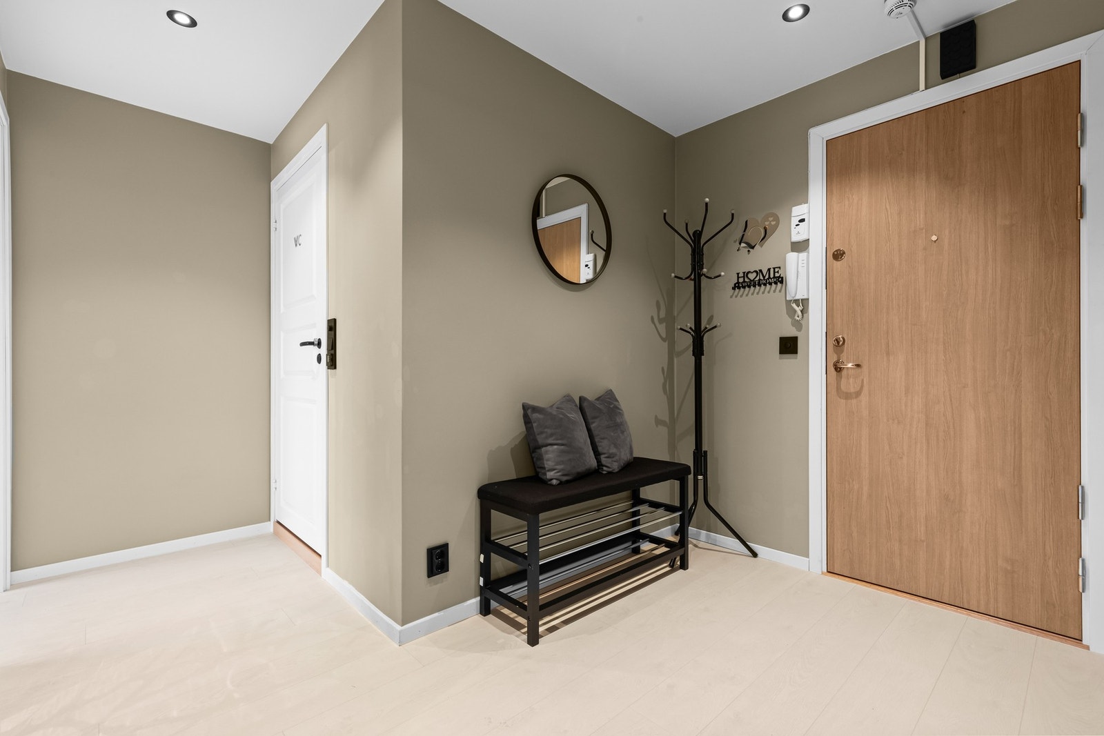 Innbydende entré med plass til sittebenk og garderobeløsning - et ryddig og praktisk førsteinntrykk av boligen. Galleribilde