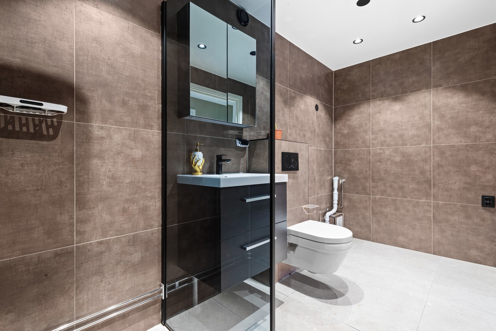 Stilrent bad med servantseksjon med skuffer og overskap med speilfronter som gir god oppbevaringsplass og et ryddig uttrykk. Galleribilde