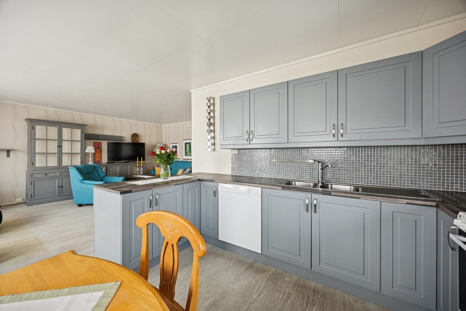 Kjøkkenet har innredning med profilerte fronter og laminert benkeplate med nedfelt vaskekum i stål. Galleribilde