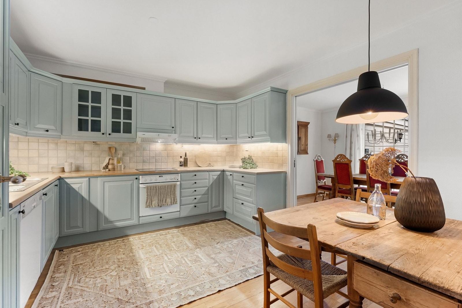 Innredning fra byggeår med malte profilerte fronter, laminat benkeplate med nedfelt vaskekum og platetopp. Fliser over benker. Integrert stekeovn. Galleribilde