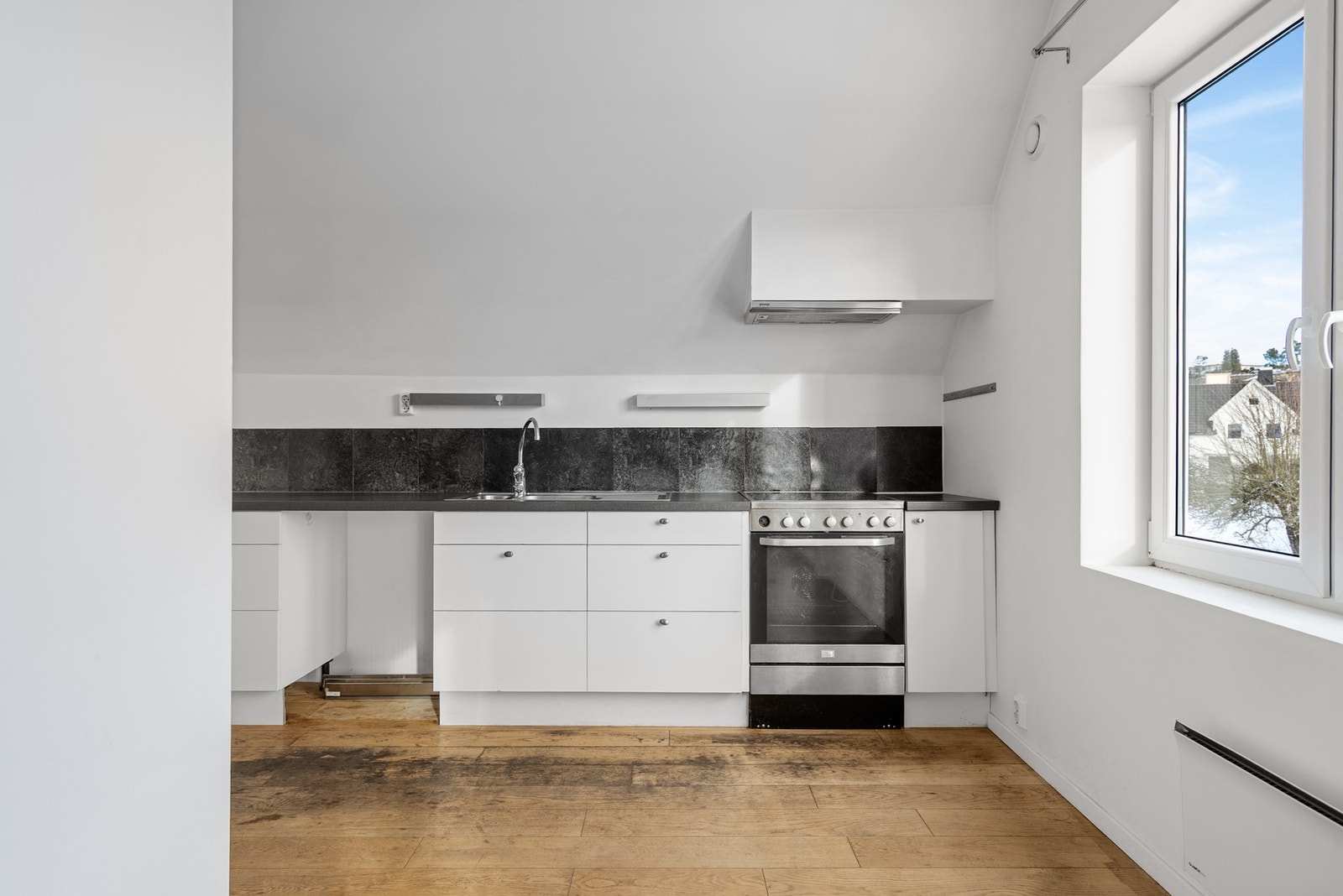 På kjøkkenet har du enkel innredning med slette fronter og plass til frittstående hvitevarer Galleribilde