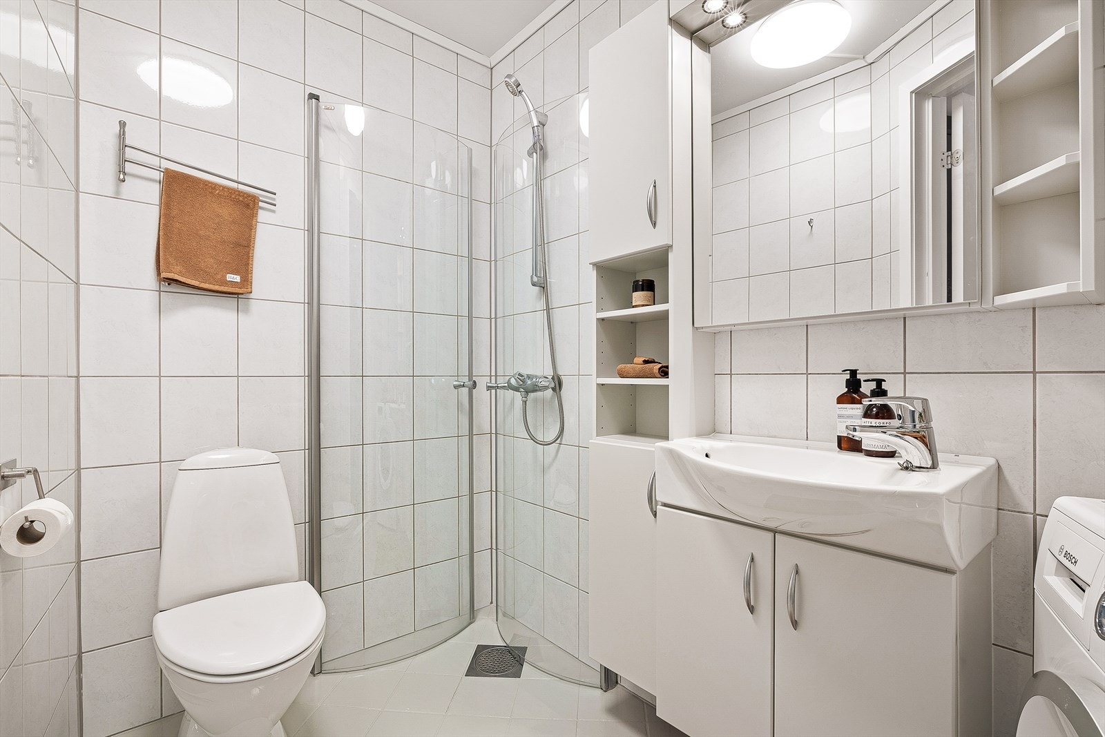 Siste stopp blir baderommet. Dette innehar alle ønskelige fasiliteter som varmekabler i gulv, et arealeffektivit dusjhjørne, toalett, samt en innholdsrik innredning med god oppbevaringsplass. Galleribilde