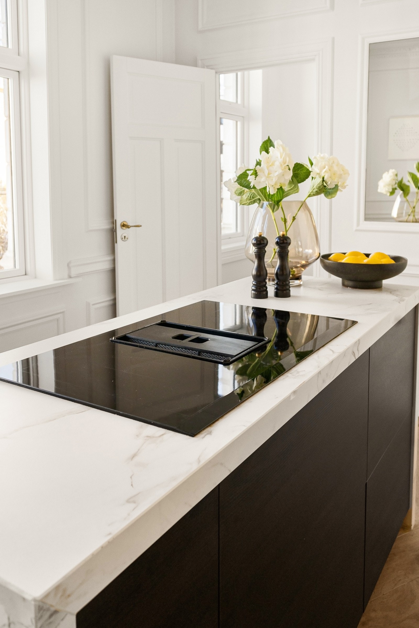 Detalj fra kjøkkenet med integrert induksjonstopp i romslig kjøkkenøy. Galleribilde