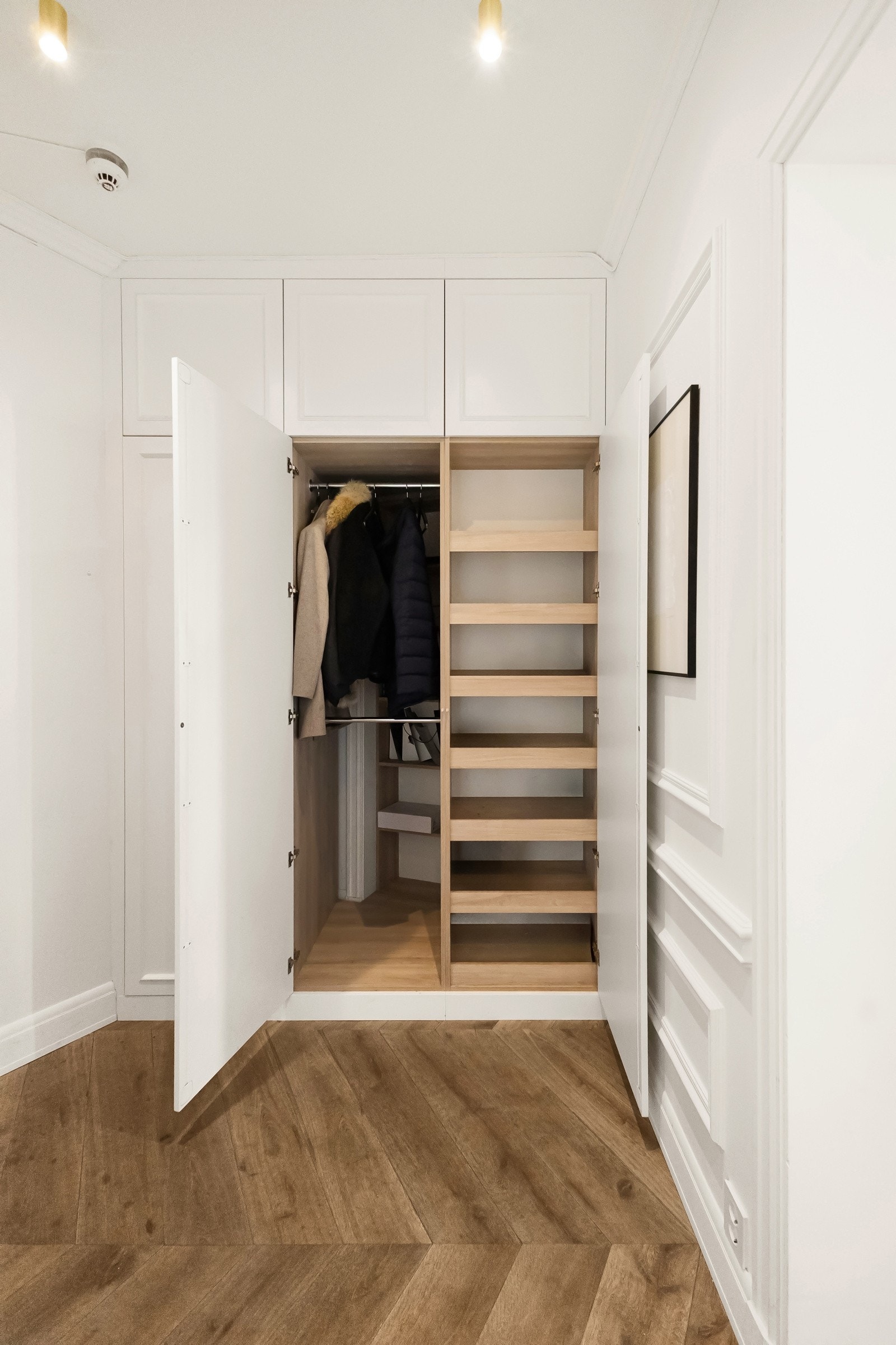 Entréen er innredet med et plassbygd garderobeskap som gir en praktisk løsning for oppbevaring av yttertøy og sko, og bidrar til et ryddig og funksjonelt inngangsparti Galleribilde
