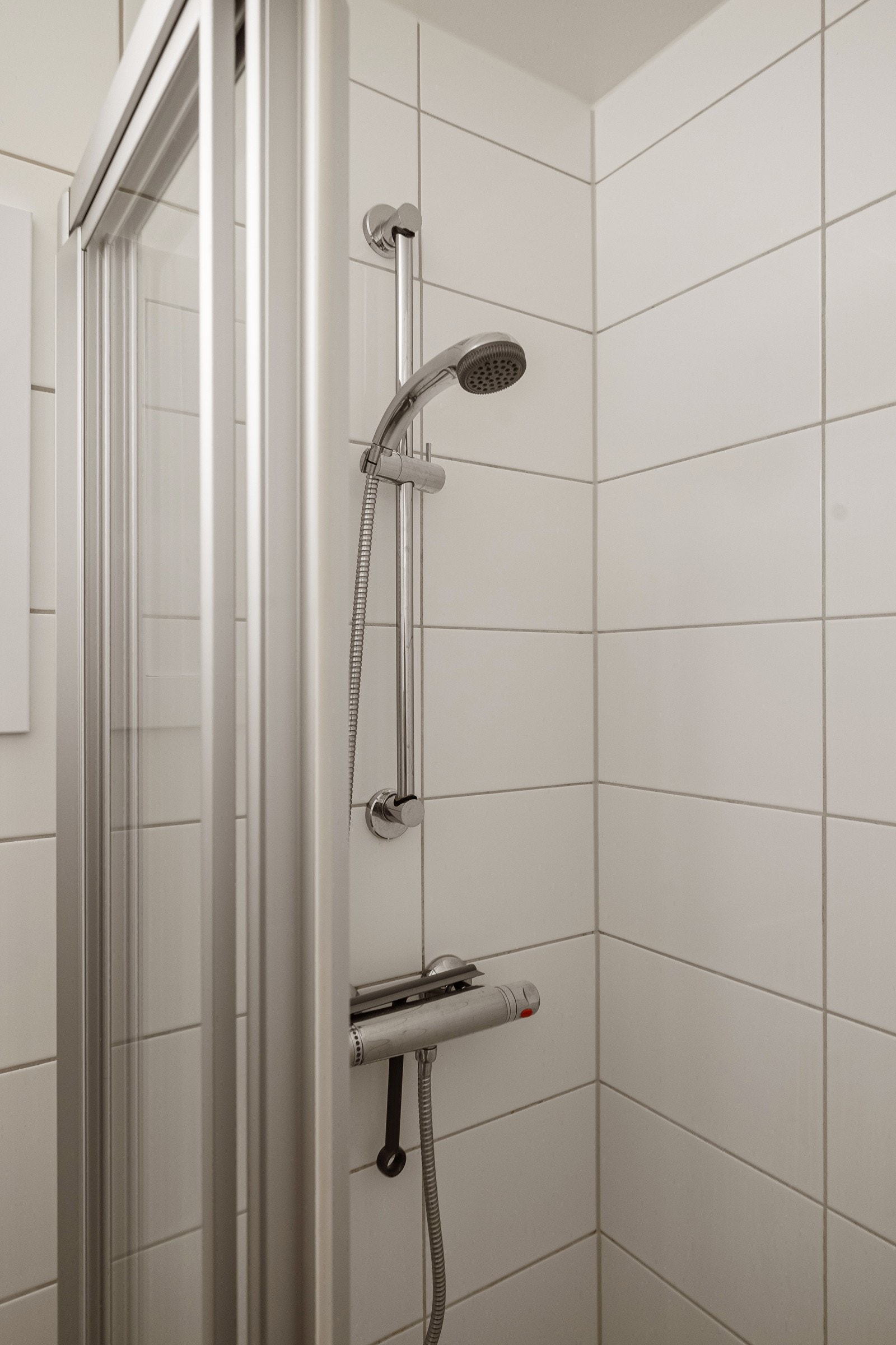 Baderommet er utstyrt med vegghengt servant, speilskap, dusjnisje med skyvedør og gulvstående toalett. Galleribilde