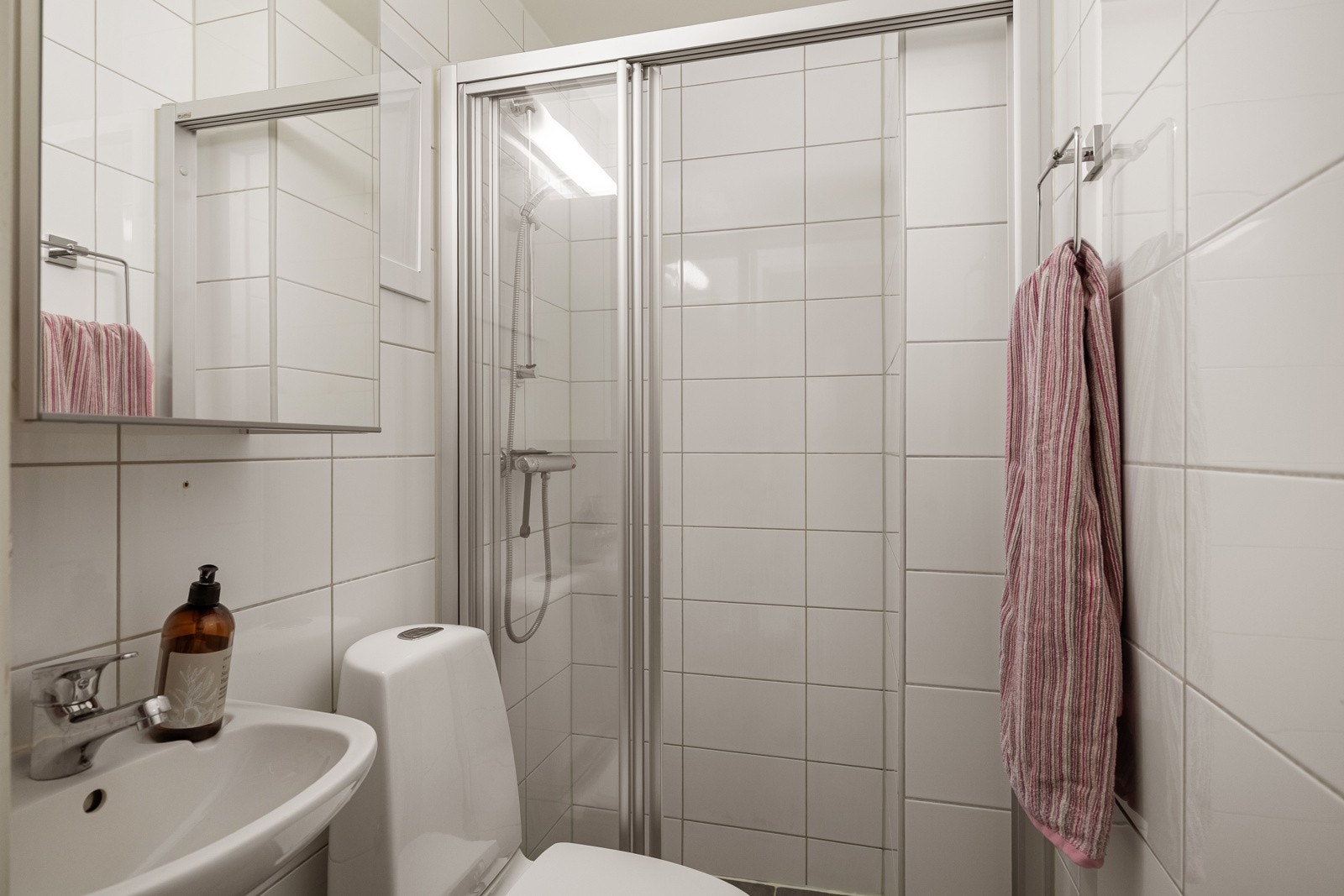 Leiligheten har et lyst og moderne flislagt baderom som ble pusset opp i regi av brl. i 2014. Galleribilde