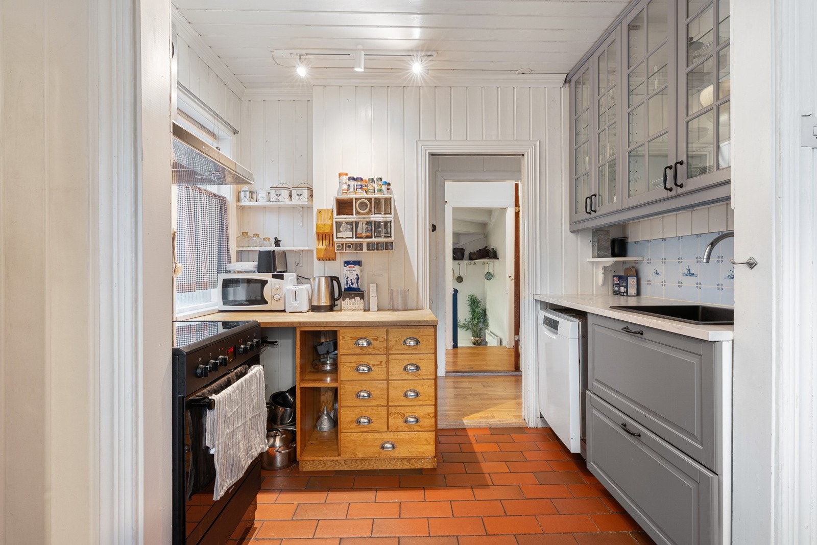 Kjøkkenet er utstyrt med frittstående hvitevarer som kjøl/fryseskap, oppvaskmaskin og komfyr.