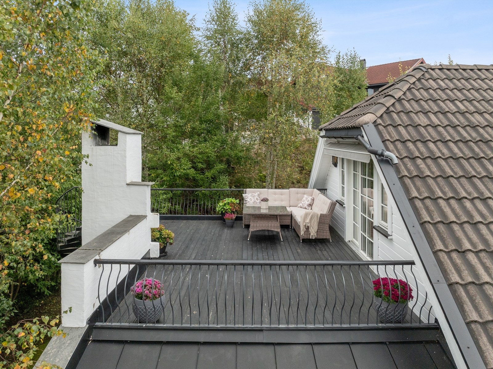 Takterrassen har smijernsrekkverk og utsyn mot grøntområde. Galleribilde