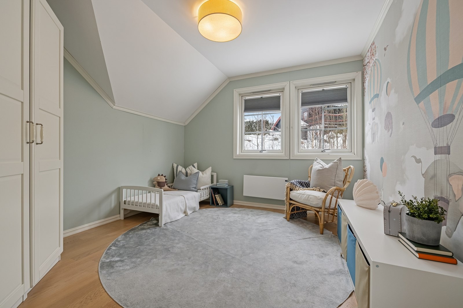 Lekkert barnerom med parkettgulv og veggdekor med lyst design. Galleribilde