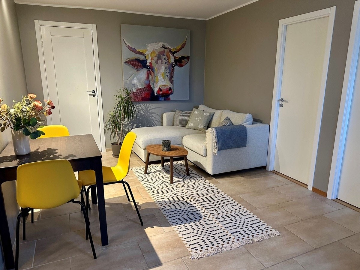 Spisegruppe og stue. Inngangen til de to soverommene er til høyre på bildet. Døren på bakveggen er inn til utleiers del av kjelleren. Galleribilde