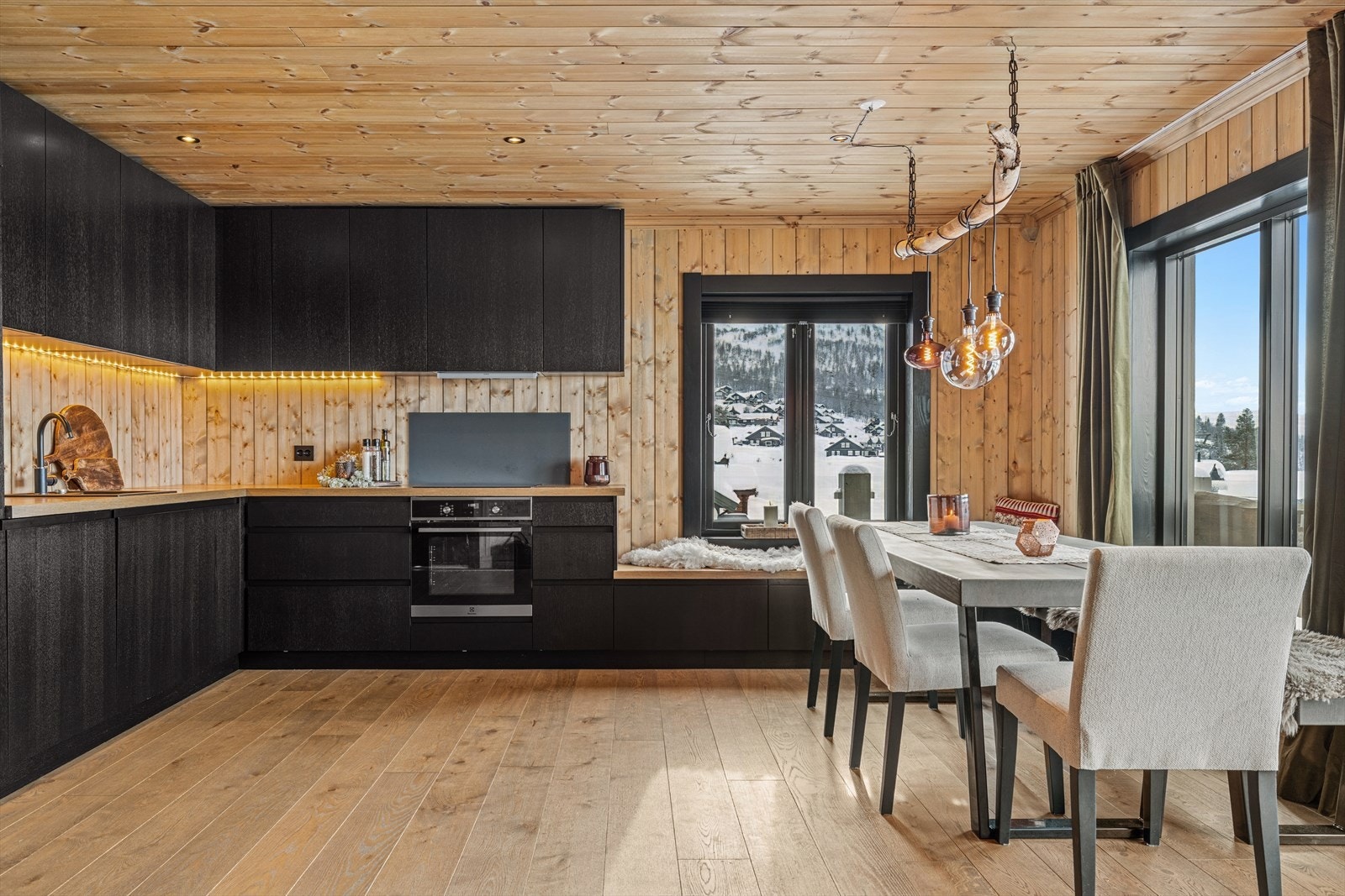 Kjøkken i moderne lodge-stil med integrerte hvitevarer og glatte fronter - både funksjonelt og estetisk tiltalende. Galleribilde