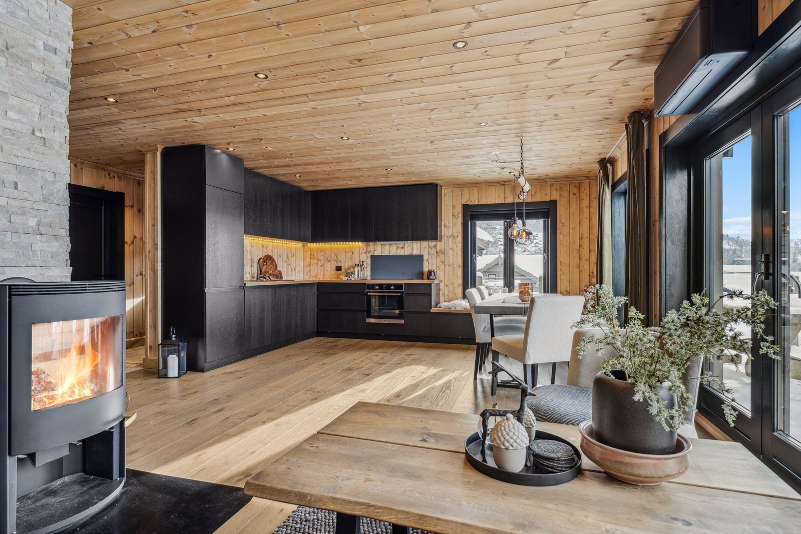 Åpen stue- og kjøkkenløsning, hvor moderne design møter praktisk funksjon - perfekt for sosiale sammenkomster. Galleribilde