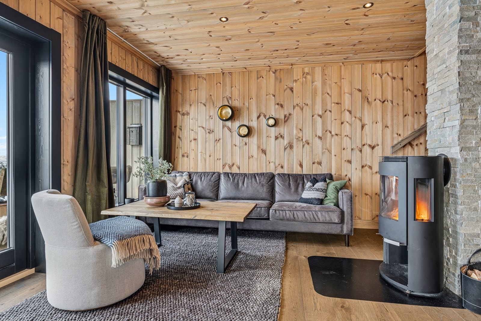 Enstavs eikeparkett og panel på vegger og himling gir et elegant, varmt og eksklusivt preg med peisovn i stuen skaper stemning og varme på kalde vinterkvelder - et naturlig samlingspunkt for familien. Galleribilde