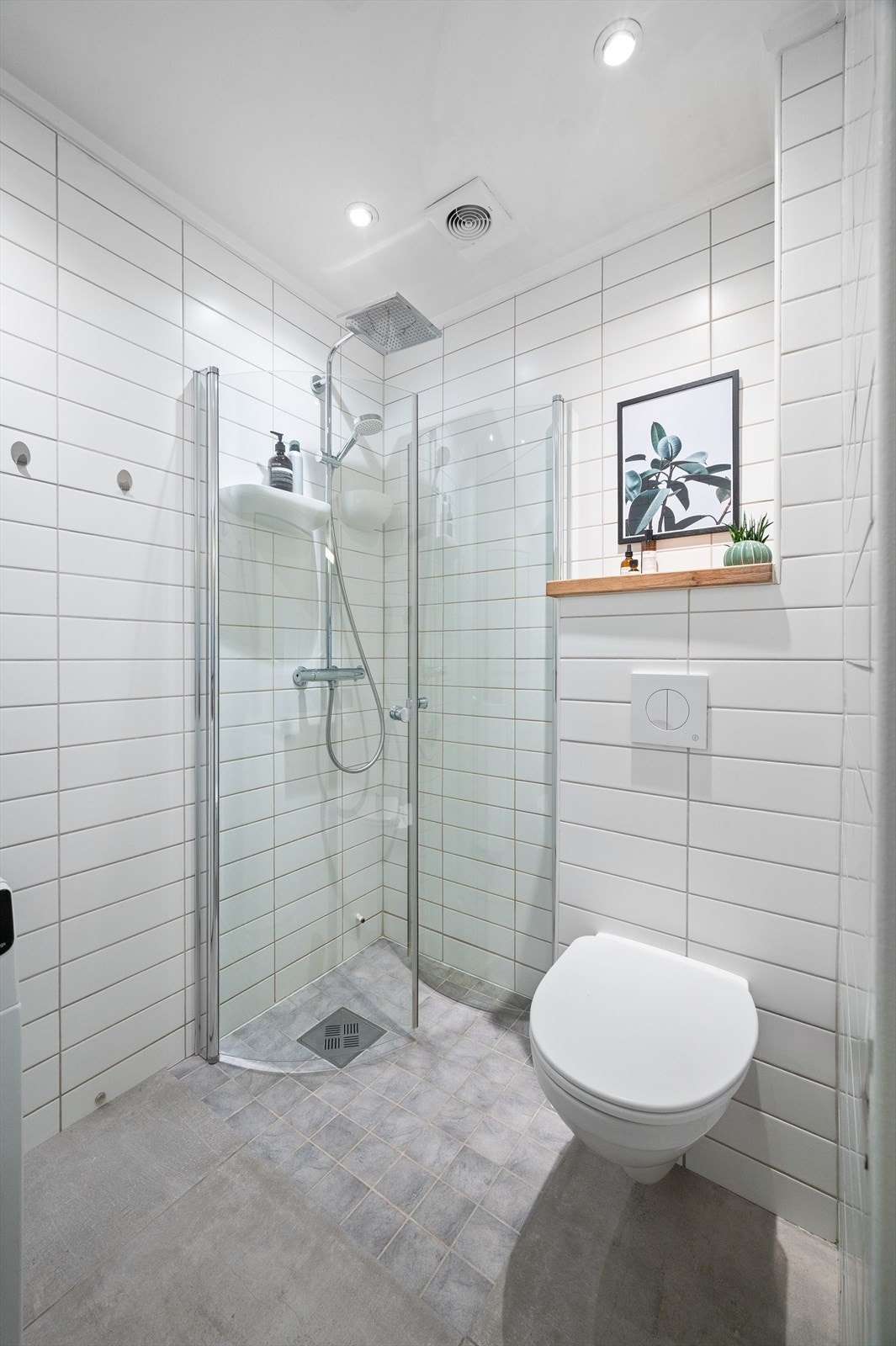 Videre har badet dusjhjørne med svingbare glassdører og innfelte downlights i taket. Galleribilde