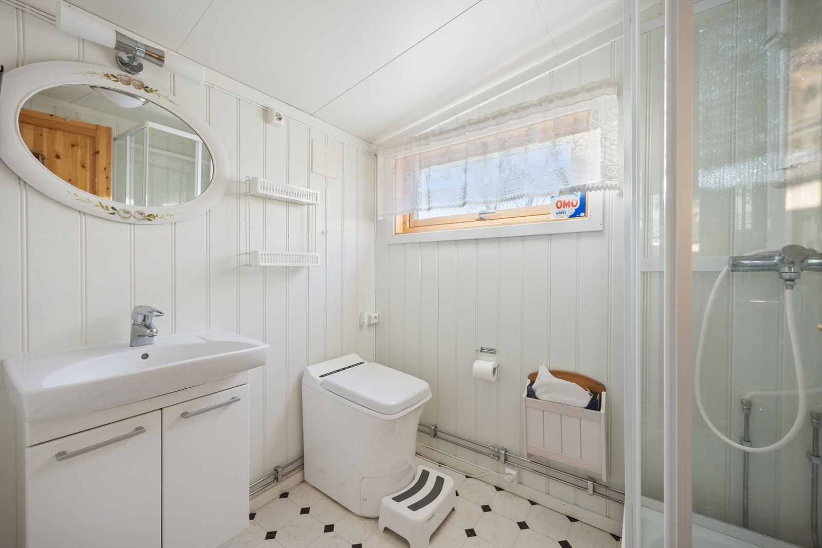 Badet har belegg på gulvet og malte plater på veggene. Galleribilde