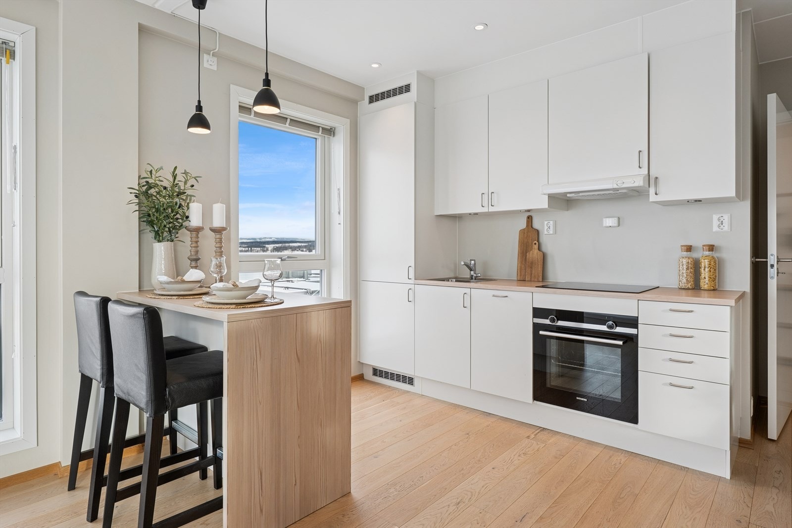 Kjøkkenet har det man trenger av benke- og skapplass og tillater sosial kokkelering med kjøkkenøy/spiseplass. Galleribilde