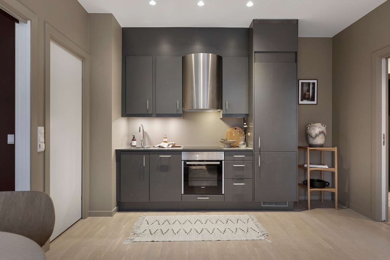 Kjøkkeninnredningen har glatte fronter og her er det bra med benkeplass samt gode oppbevaringsmuligheter i over- og underskap. Galleribilde