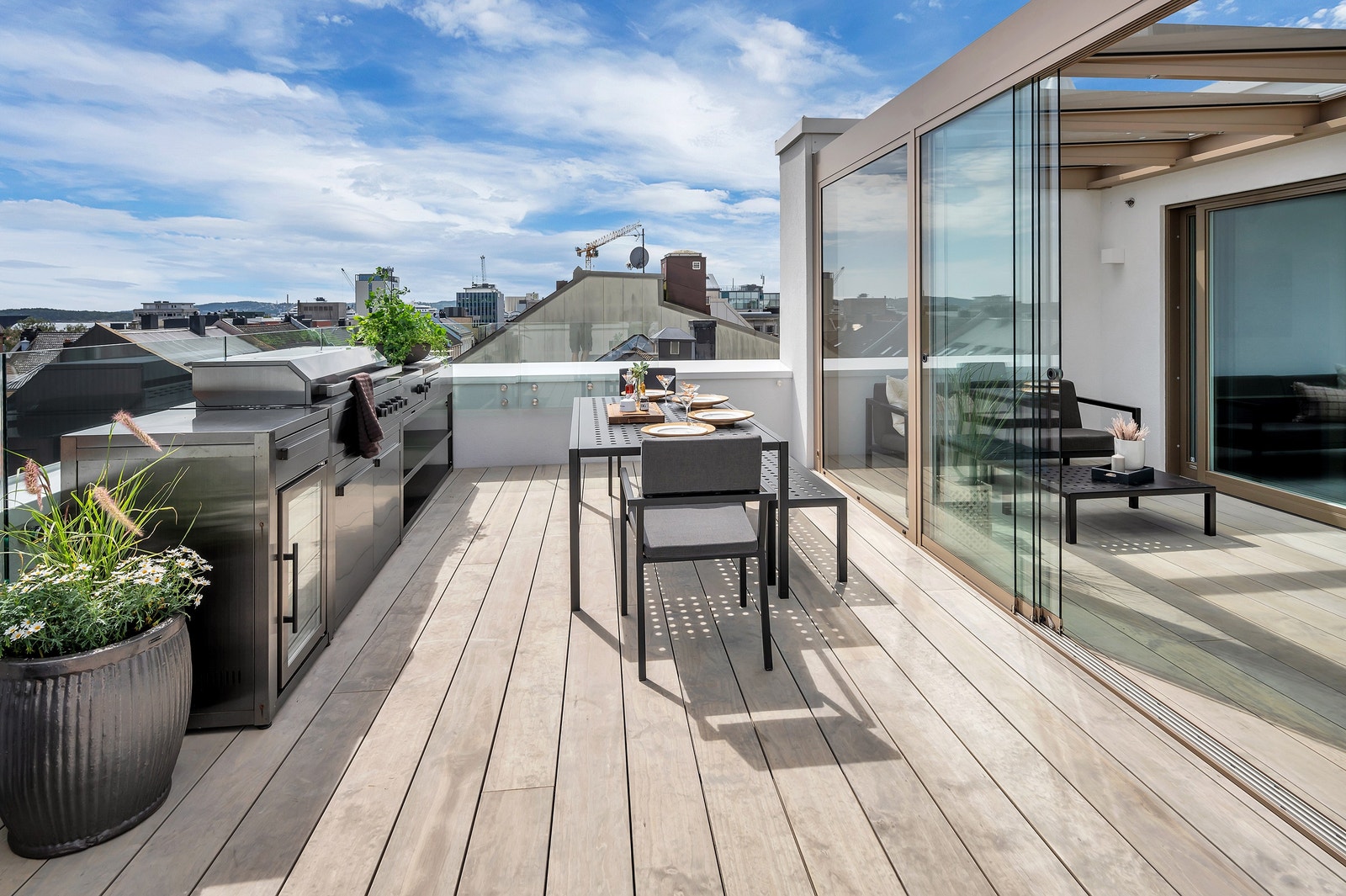 Fra oppholdsrom i 6 etg tar du deg ut til innglasset balkong/pergola og til et stort utekjøkken. Galleribilde