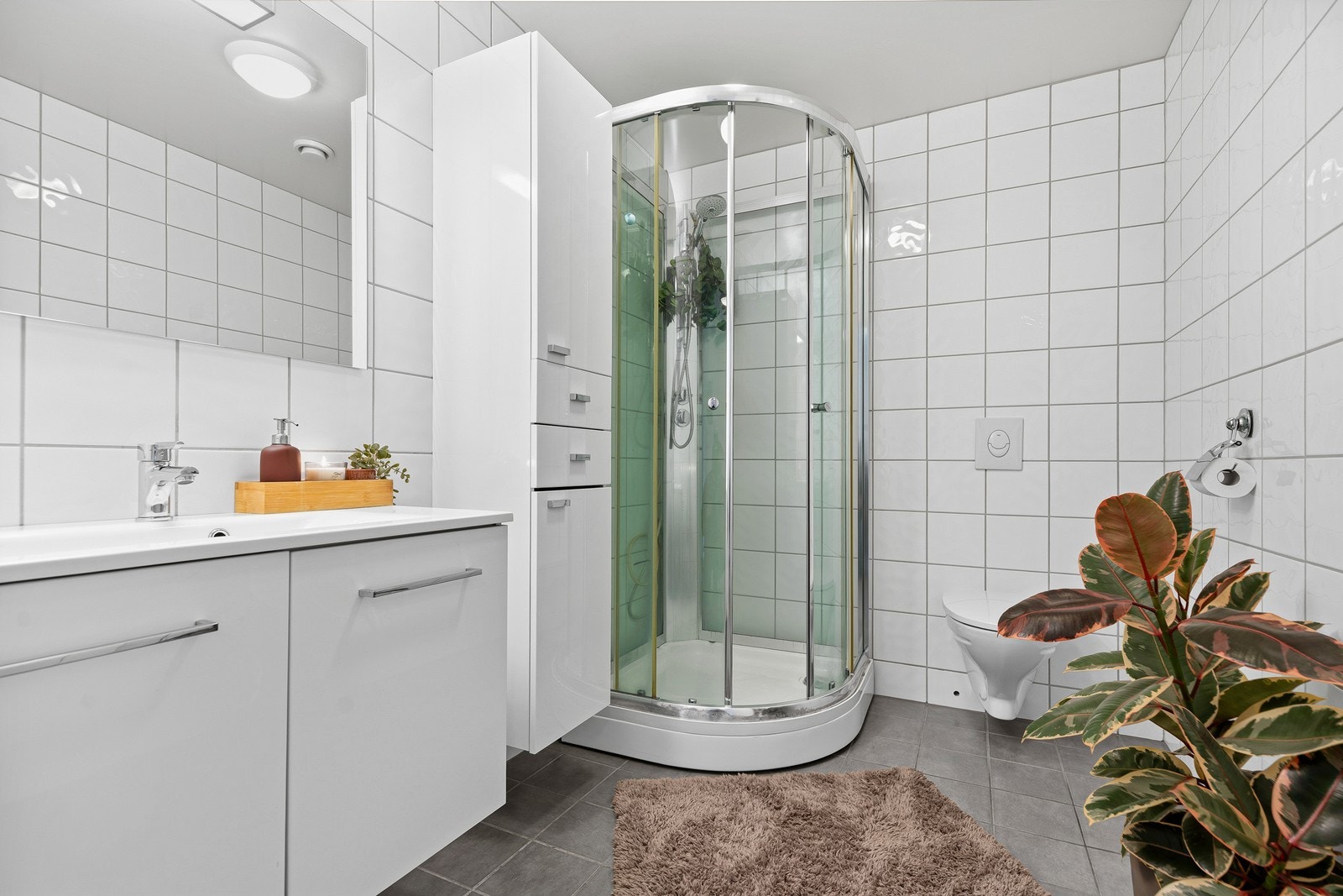 Flott baderom bestående av baderomsinnredning, dusjkabinett og toalett. Galleribilde