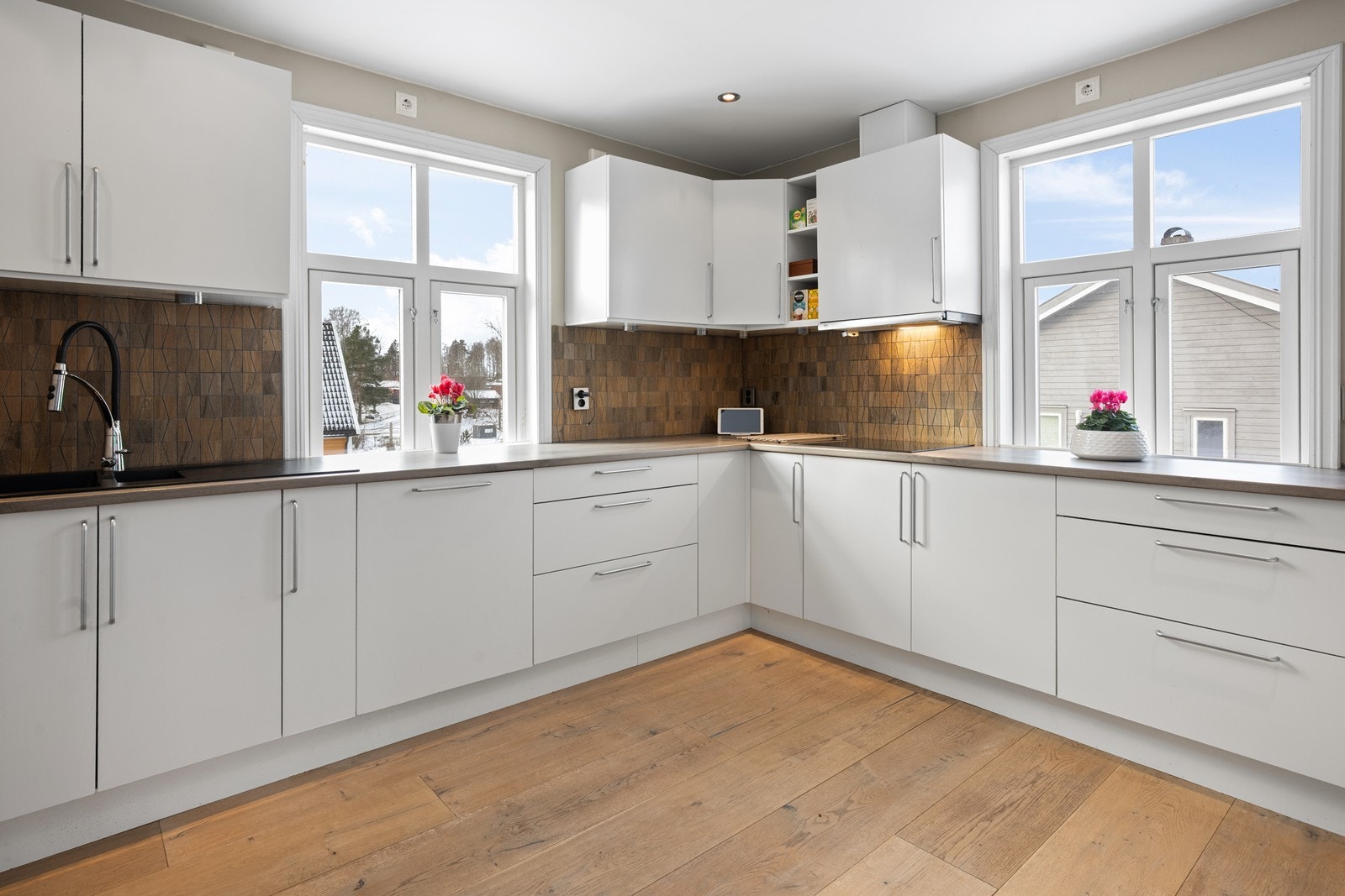 Lyst og romslig kjøkken med rikelig naturlig lys og god plass til matlaging Galleribilde