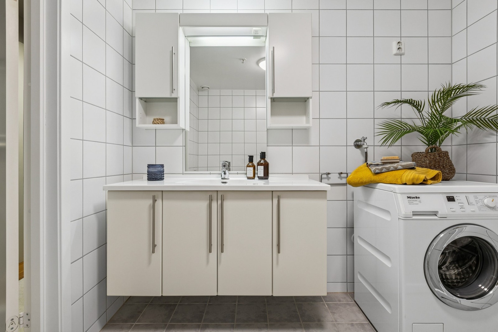 Badet har vegghengt servantskap med heldekkende servant, gulvmontert toalett og opplegg for vaskemaskin. Galleribilde