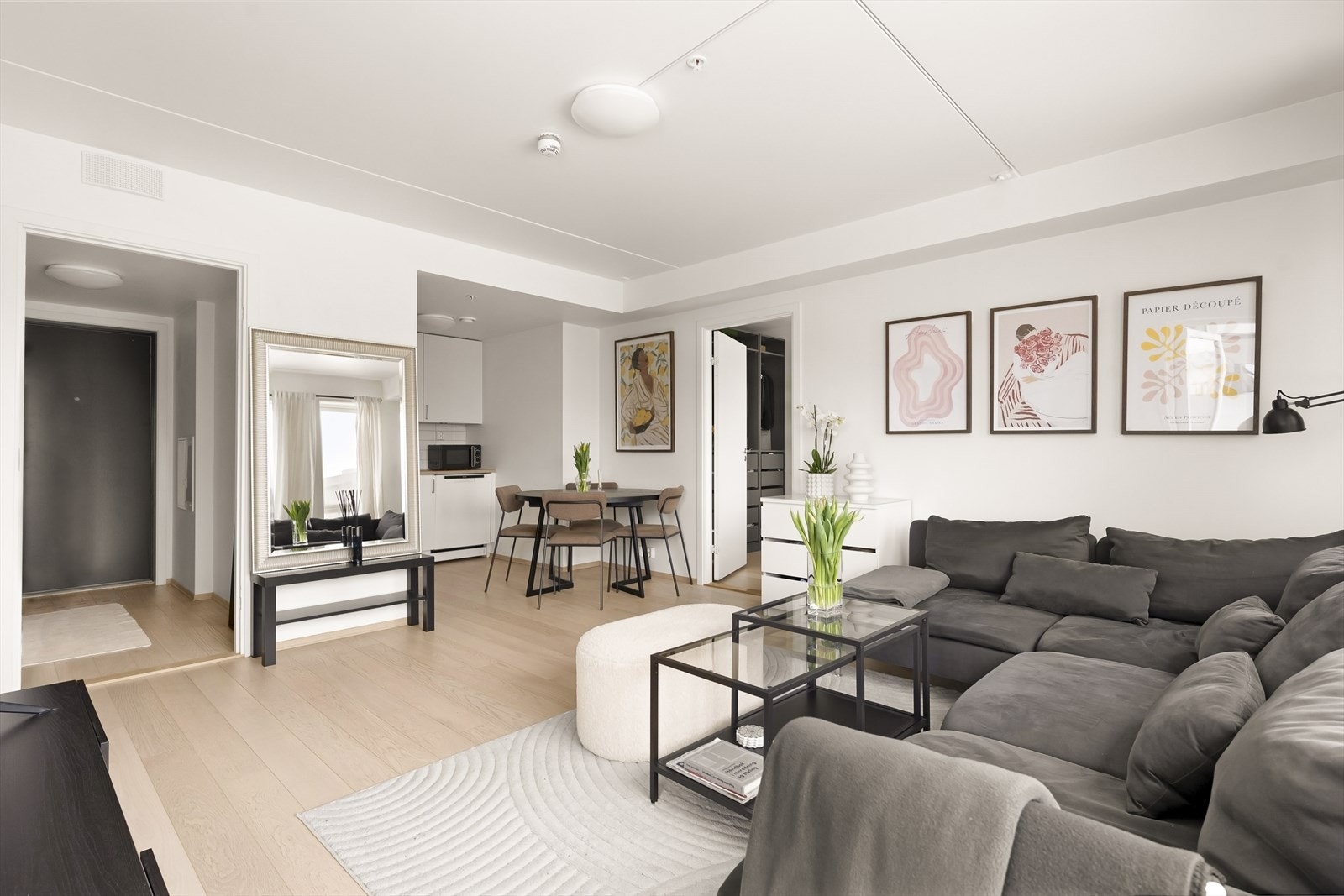 Den åpne løsningen mellom stue og kjøkken skaper en sosial og innbydende sone i leiligheten. Galleribilde