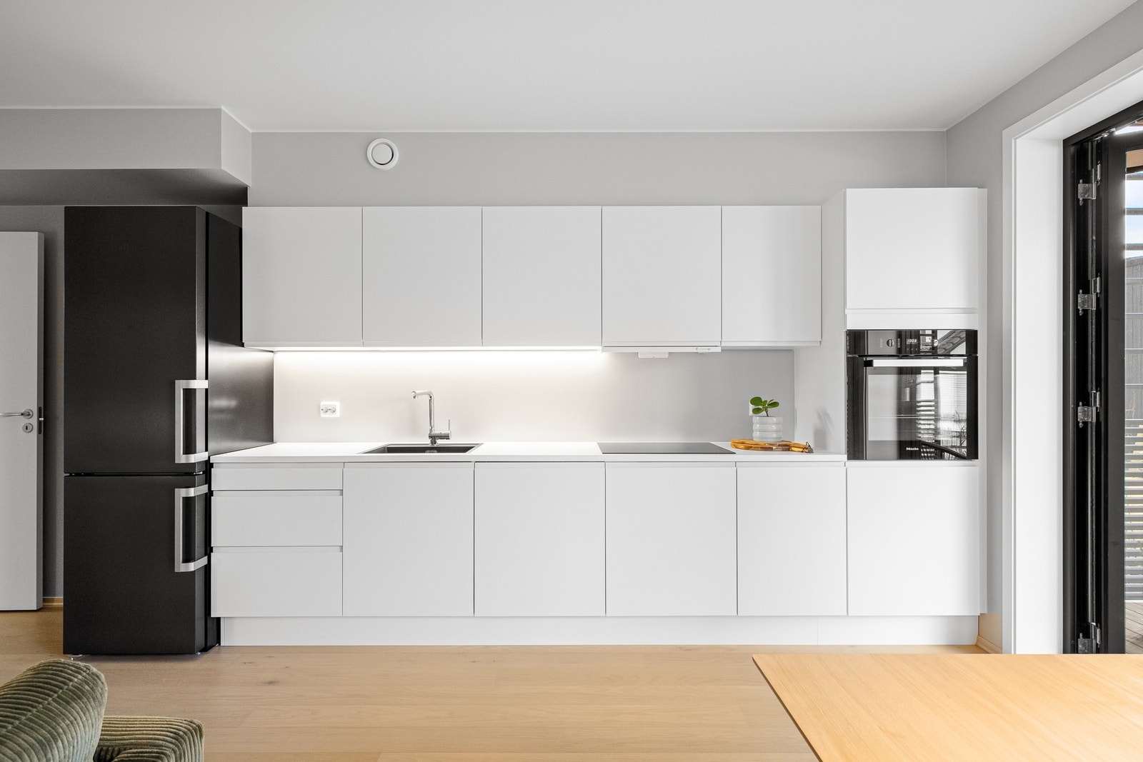 Moderne kjøkken med integrerte hvitevarer og rene linjer. Galleribilde