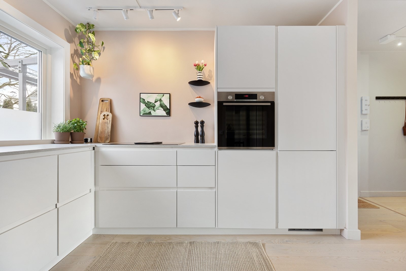 Innredningen har slette lyse fronter og benkeplate i laminat med nedfelt oppvaskkum. Videre er kjøkkenet utstyrt med integrert oppvaskmaskin, komfyr, kjøleskap med frysedel, samt nedsenket induksjonstopp med integrert ventilator med kullfilter. Galleribilde