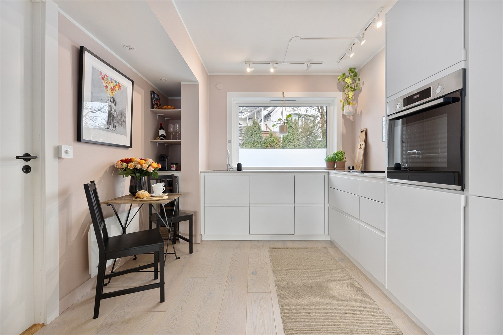 Leiligheten har et pent kjøkken fra 2018 i delvis åpen løsning. Innredningen har slette lyse fronter og benkeplate i laminat med nedfelt oppvaskkum. Galleribilde