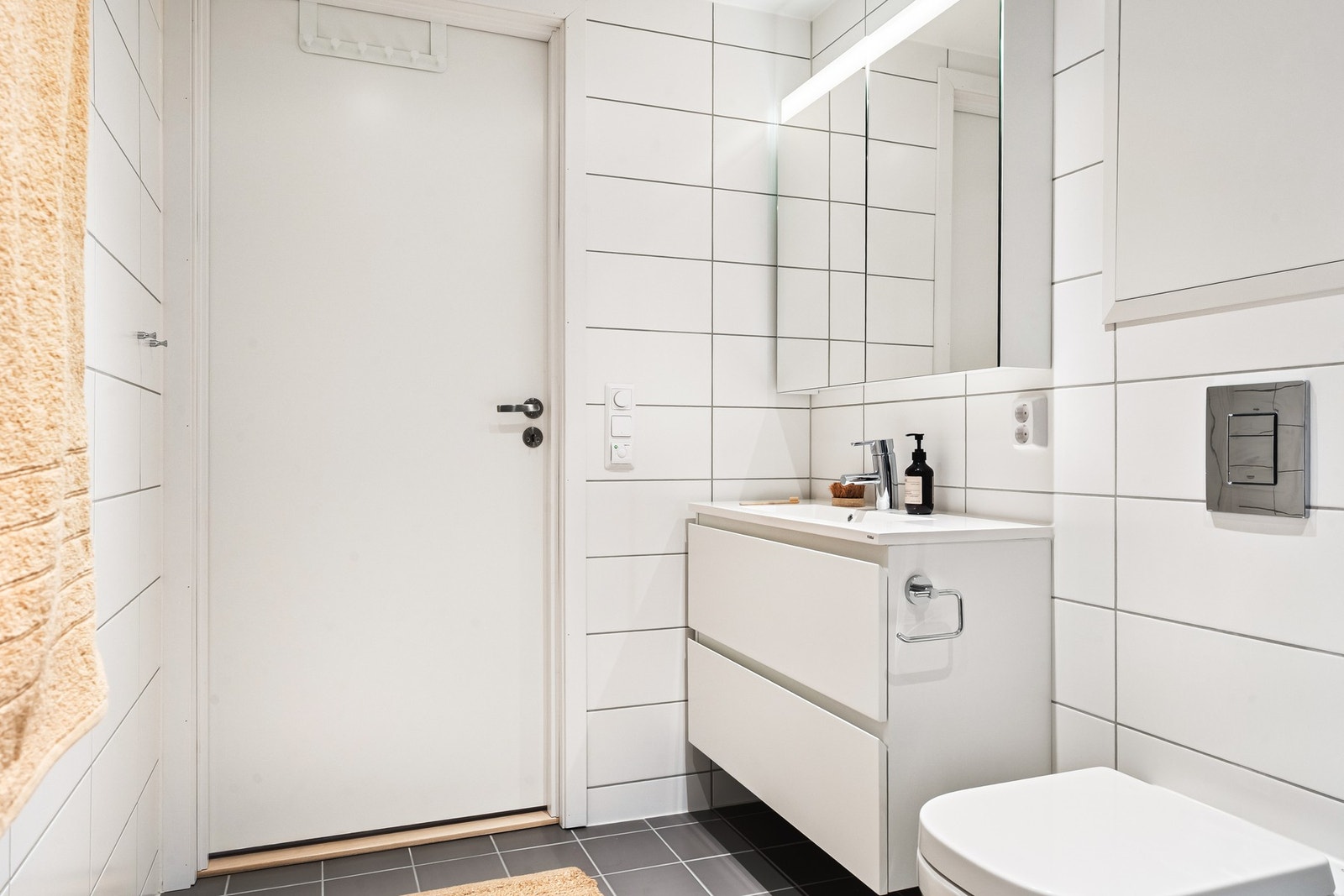 Det er innredet med vegghengt toalett, dusj med glassvegger og baderomsinnredning med speil og belysning. Galleribilde