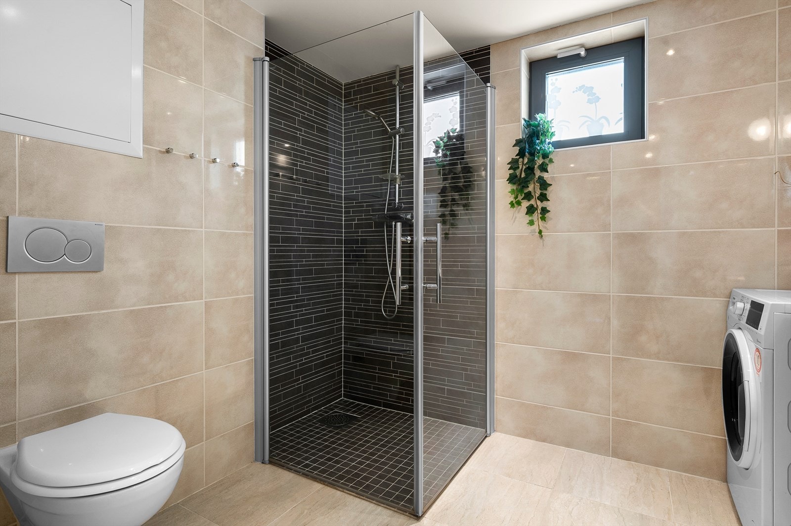 Baderommet er videre innredet med et lekkert dusjhjørne med innfellbare glassdører. Galleribilde