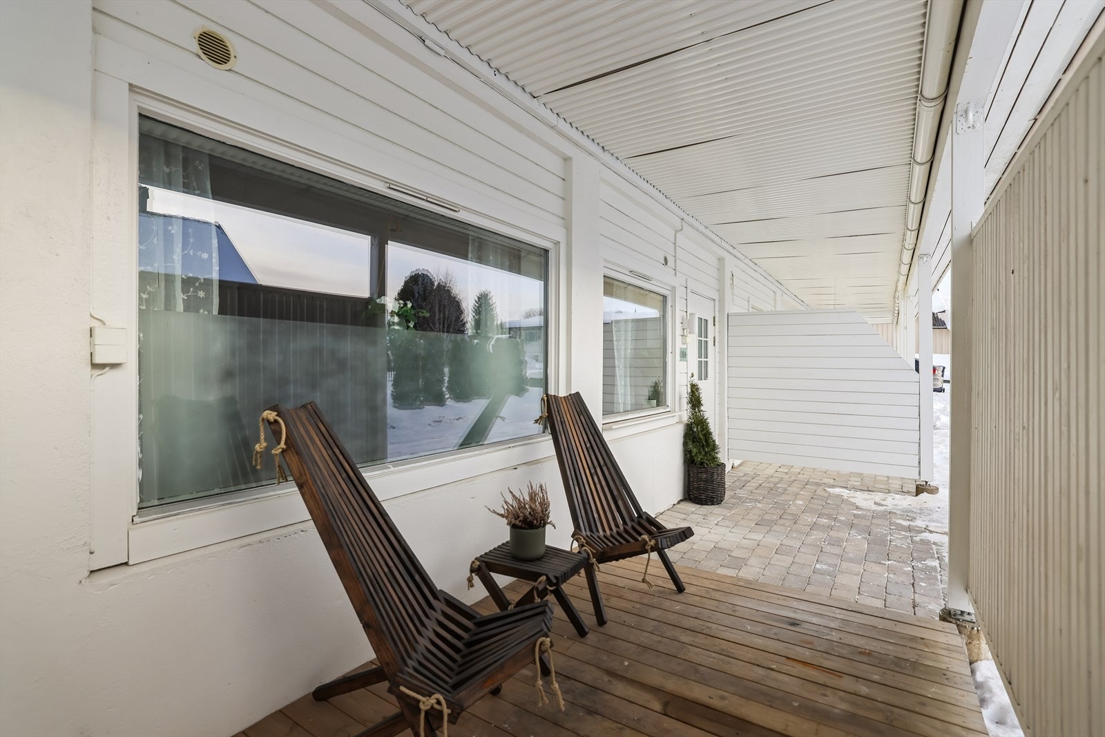 Ved inngangspartiet er det en overbygget terrasse med levegg som gir en skjermet uteplass. Galleribilde