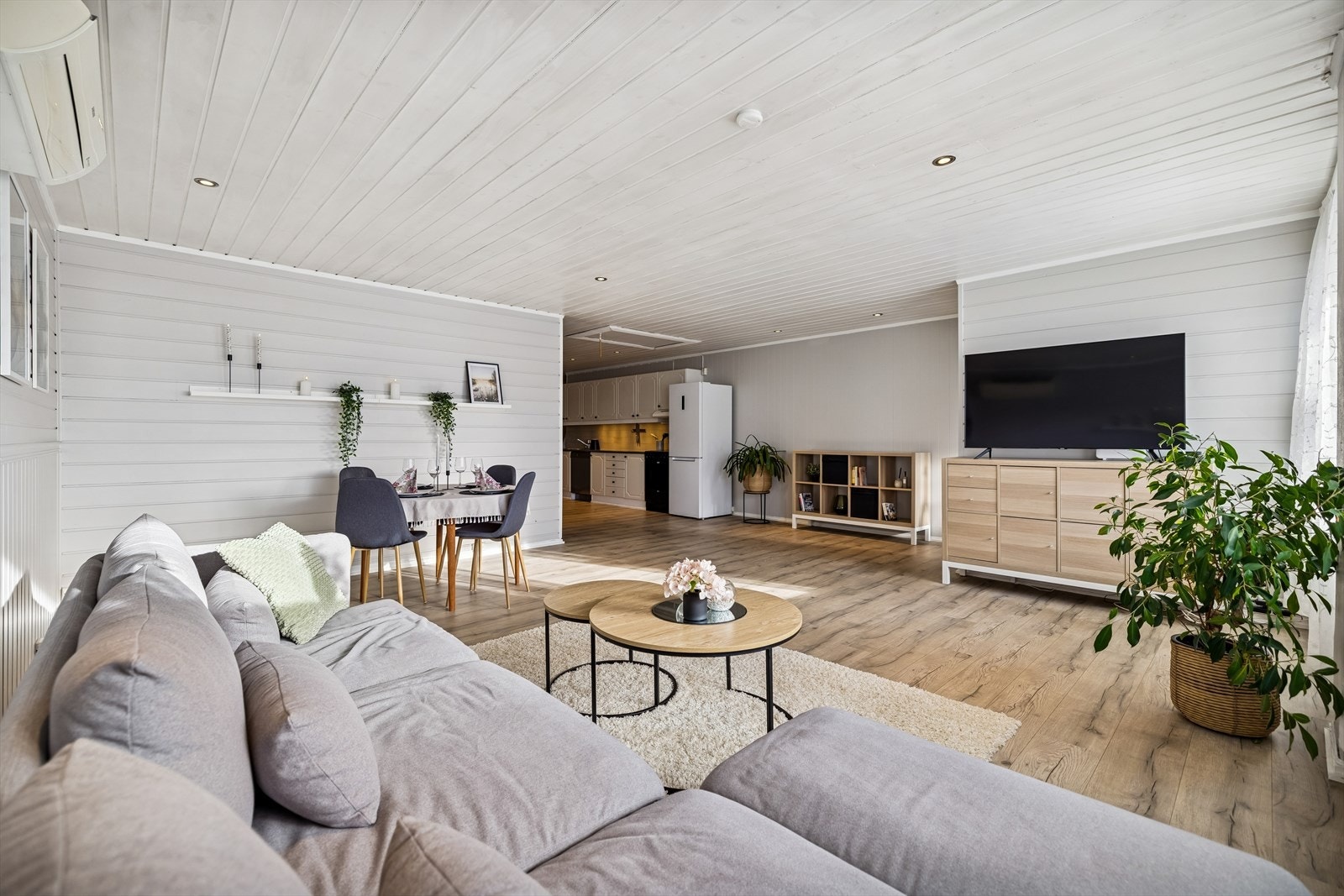 Gjennomgående bruk av laminatgulv (2019) og malt panel på vegger (2025) gir et helhetlig inntrykk. Galleribilde