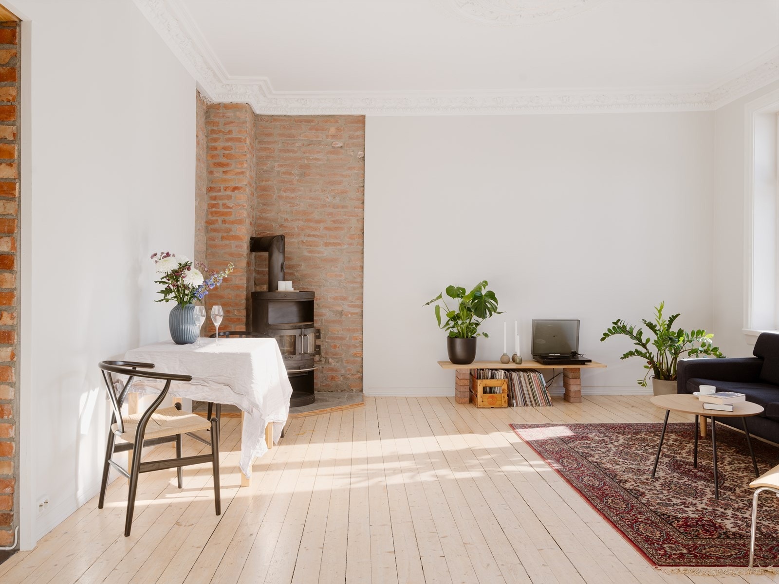 Den åpne planløsningen sammen med den gode takhøyden på ca 3 meter bidrar til varierte møbleringsmuligheter og en herlig romfølelse. En sjarmerende peisovn plassert i hjørnet sørger for knitrende varme i vinterhalvåret. Galleribilde