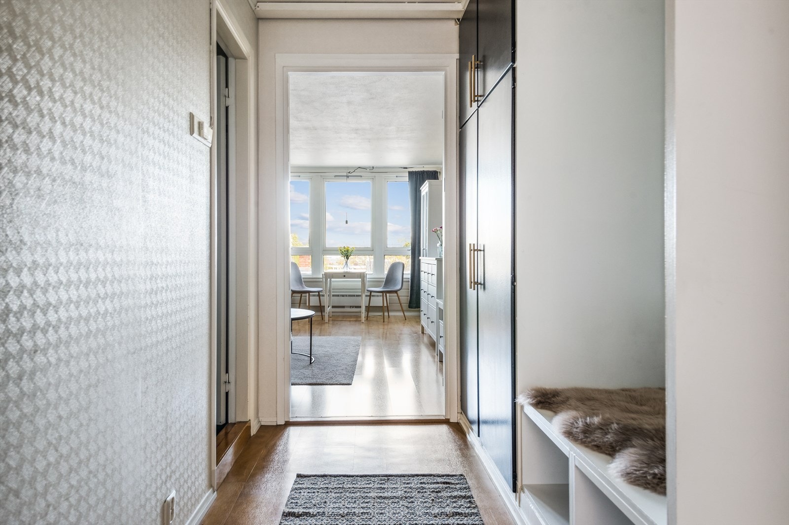 Man ønskes velkommen inn i en lys og innbydende gang med god garderobeplass langs veggen, som gir ryddige og praktiske oppbevaringsmuligheter. Galleribilde