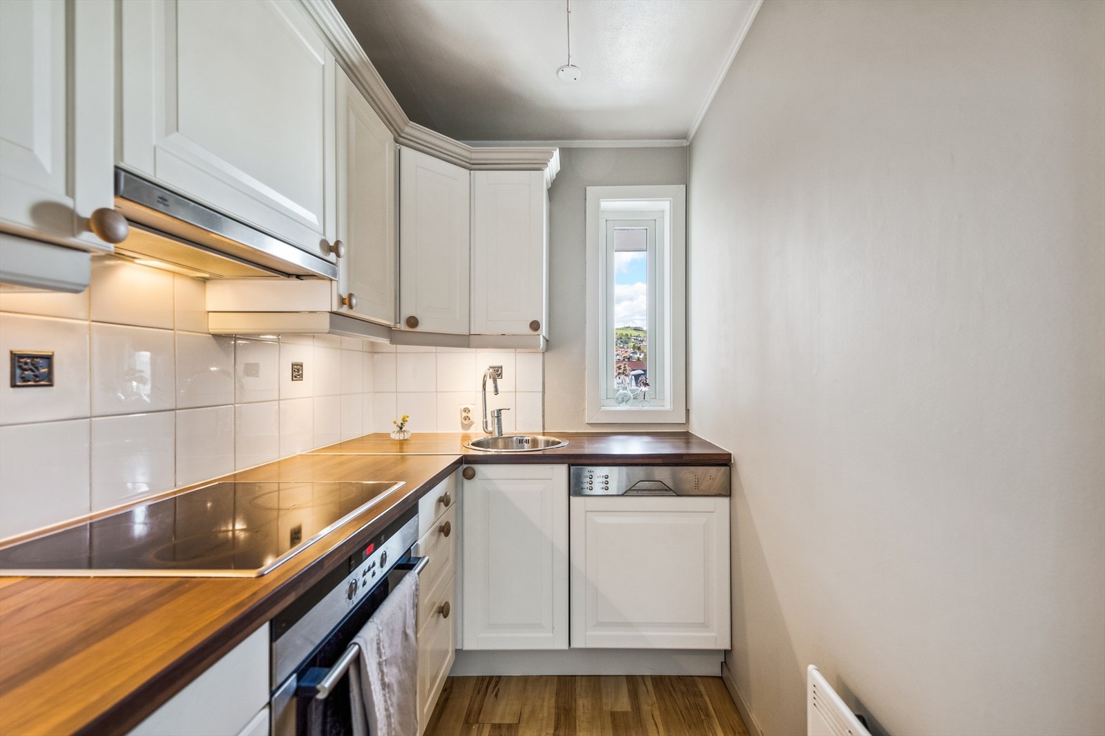 Kjøkkenet ligger i en delvis åpen løsning mot stuen, og innredningen er fra 2009 med laminerte skrog, profilerte fronter og laminert benkeplate. Galleribilde