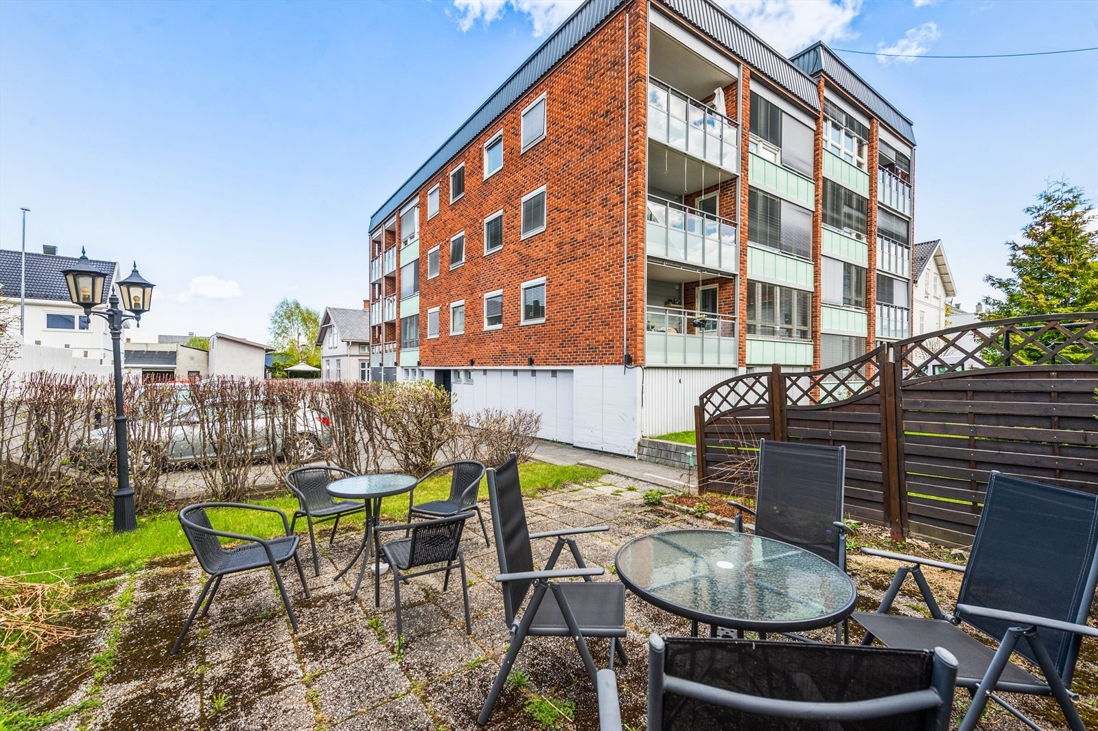 Felles festet flat tomt som er pent opparbeidet med gressplen samt noe beplantning. Galleribilde