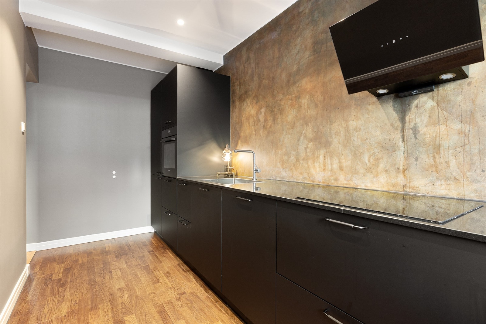 Vegger med behandlet mikrosement over benken gir et unikt og vedlikeholdsvennlig preg. Parkett på gulv og downlights i himling, alt nytt i 2024. Galleribilde