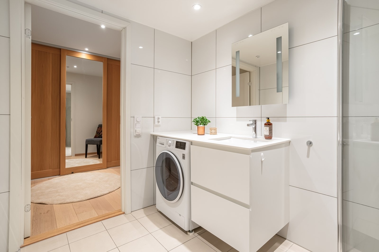 Delikat flislagt baderom med downlights i tak og behagelig gulvvarme. Opplegg for vaskemaskin under benk Galleribilde