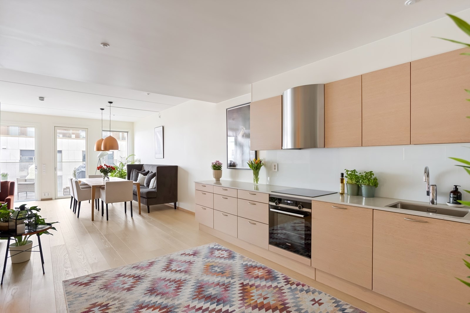 HTH kjøkkeninnredning med finerte eikefronter og benkeplate i stein Galleribilde