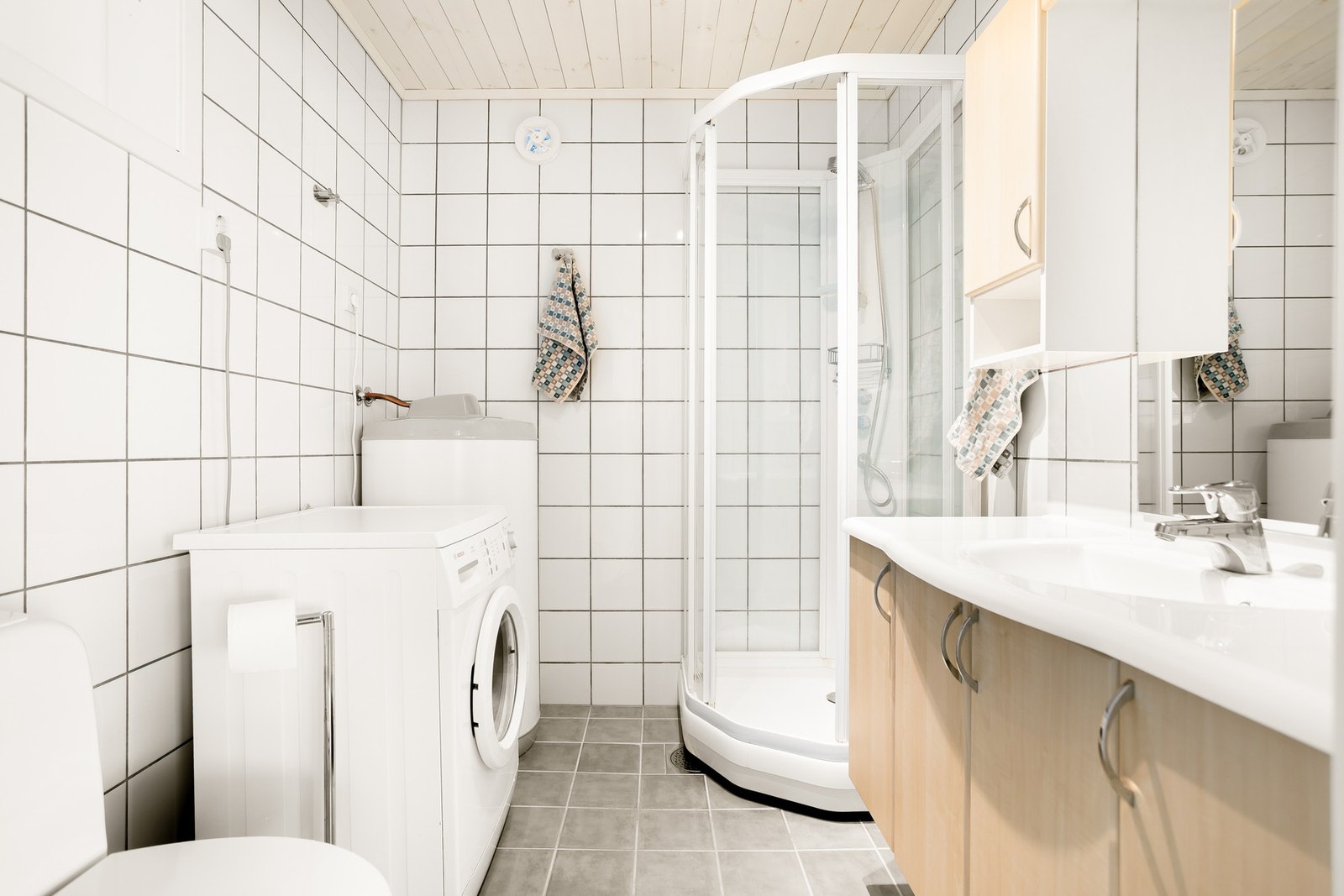 Ekstra bad med flislagte vegger og opplegg til vaskemaskin. Galleribilde