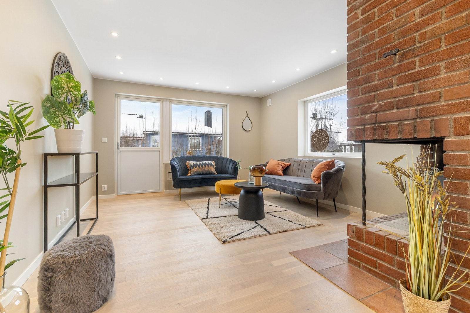 Stuen fremstår svært lys med store vindusflater, i tillegg er det montert spotter i taket. Galleribilde