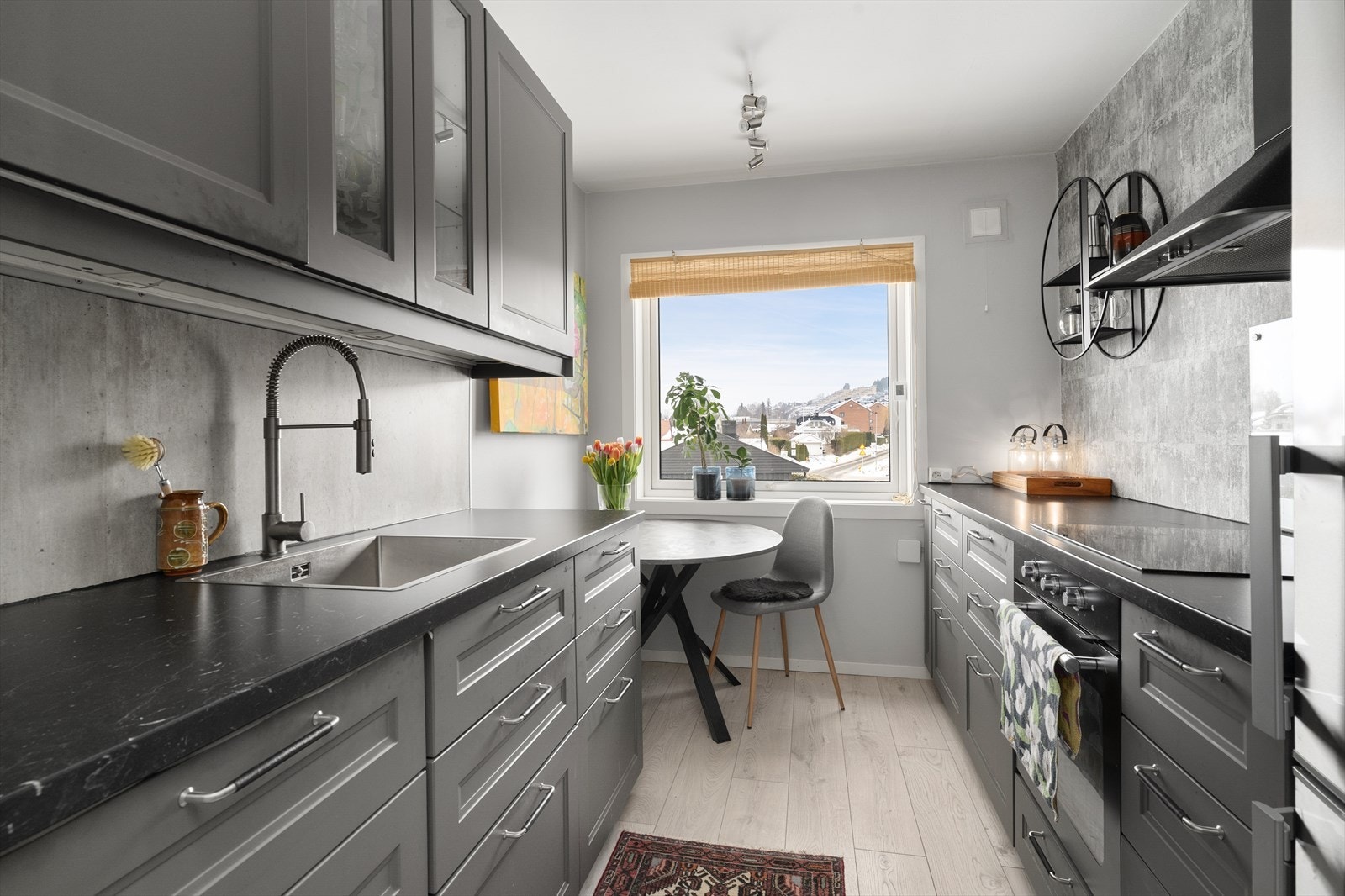 Kjøkkenet har en pen innredning med profilerte fronter og noe glasskap, laminerte benkeplater og beskyttelsesplate over kjøkkenbenk. Ved vinduet er det plass til et spisebord. Galleribilde