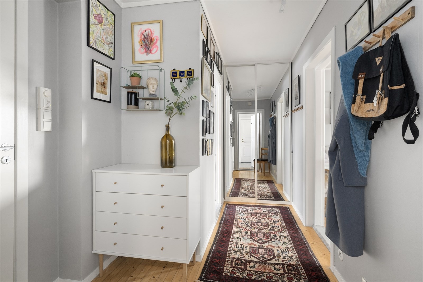 Entreen er romslig, og har god plass til oppbevaring av sko og yttertøy. Her er det også en praktisk skyvedørsgarderobe med speildører. Galleribilde