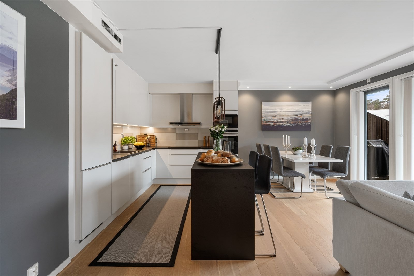 Stilren kjøkkeninnredning fra HTH med laminert benkeplate, slette fronter og fliser mellom benkeplate og overskap. Galleribilde