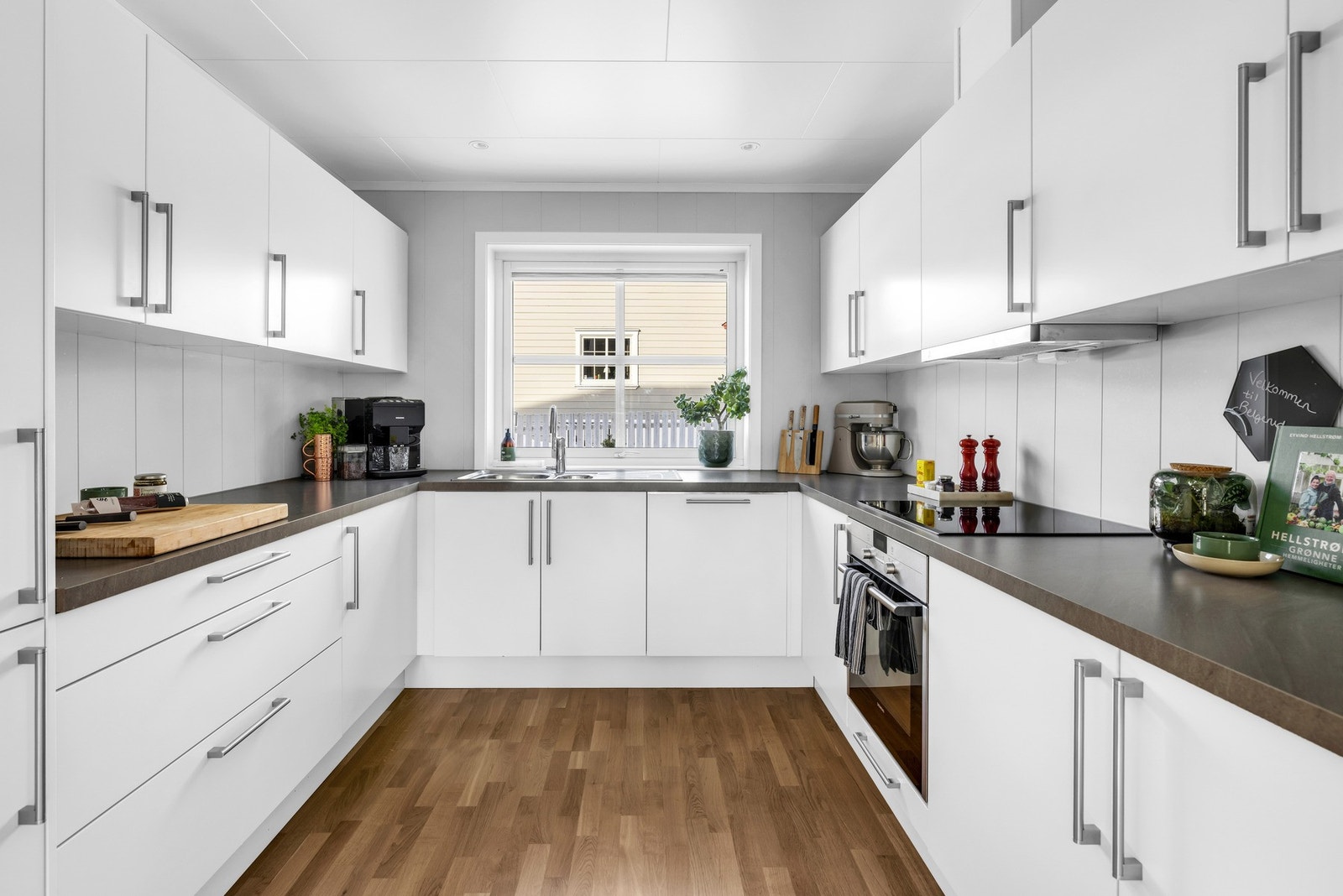 Den U-formede kjøkkeninnredningen byr på god arbeidsflyt med store benkeoverflater og rikelig med skapplass. Galleribilde