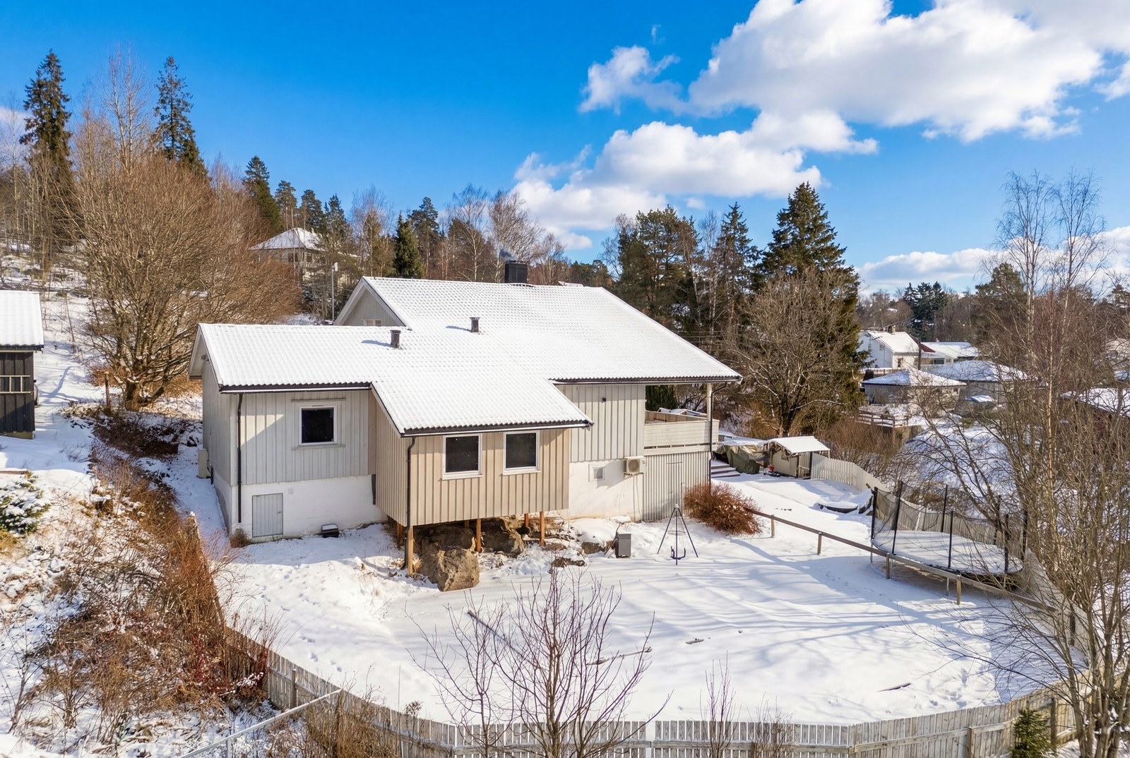 Fin uteplass bak huset med stor platting. Galleribilde