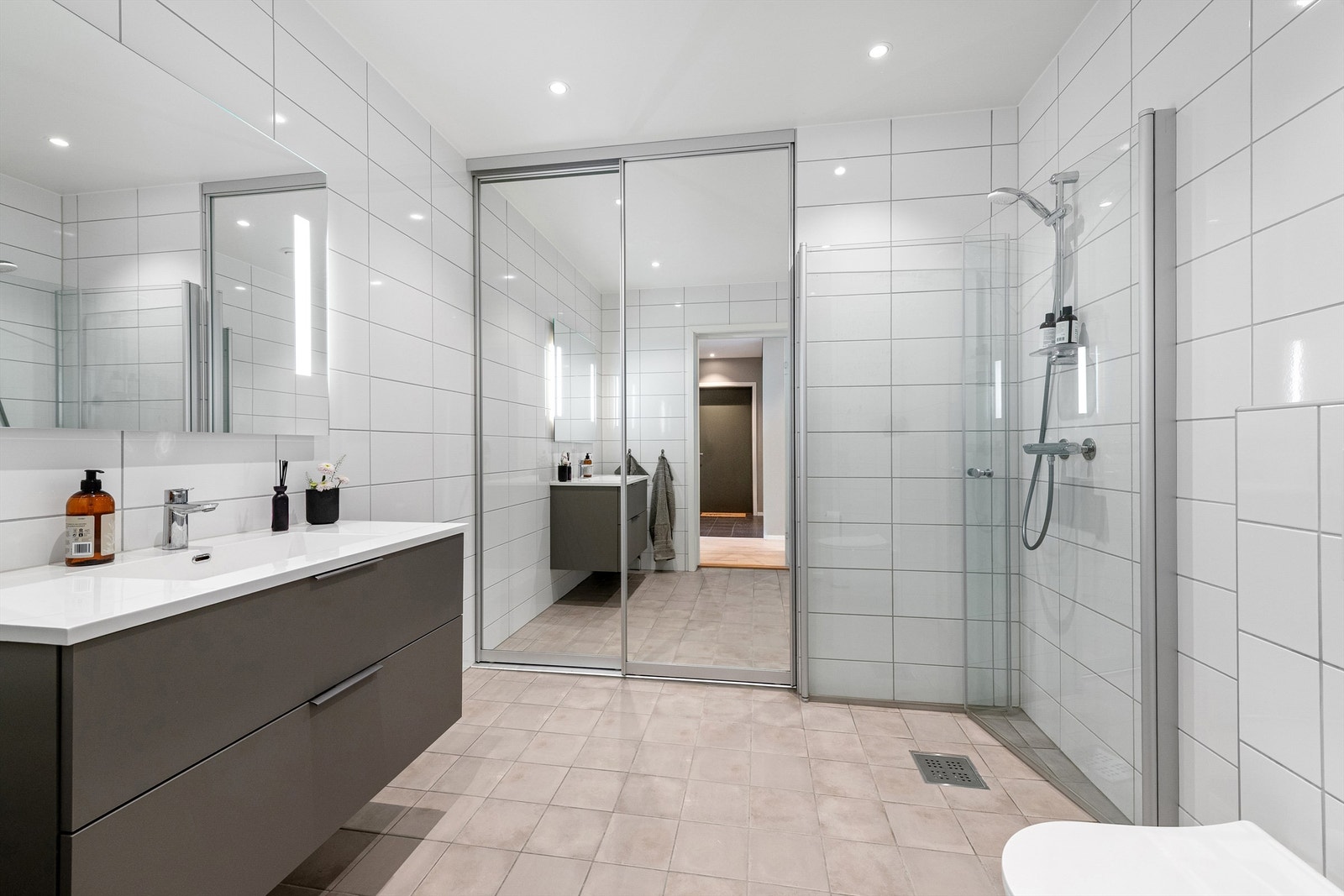 Flislagt bad fra 2020 med innredning fra HTH, veggmontert toalett og dusjvegger av glass. Galleribilde