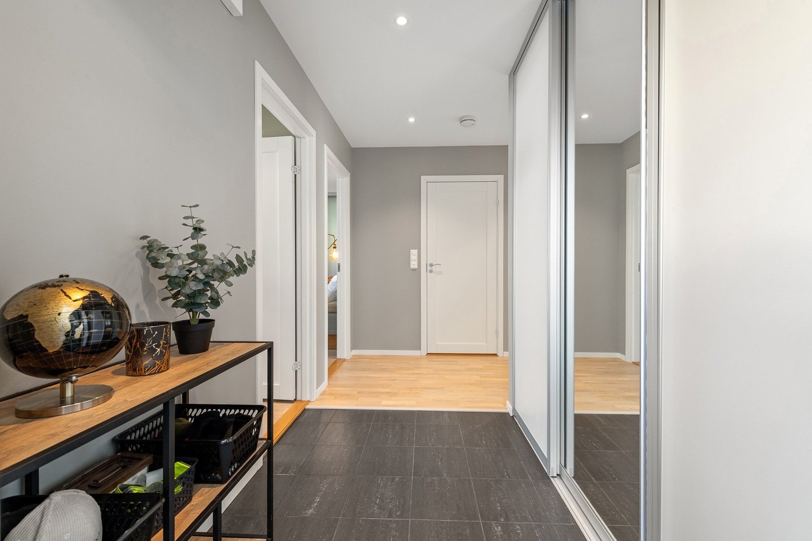 Innbydende entré med flislagt gulv med gulvvarme og god oppbevaringsplass i skyvedørsgarderobe. Galleribilde